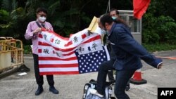 Seorang demontran pro-Beijing menginjak poster bergambar ketua DPR AS Nancy Pelosi dalam aksi protes di depan gedung Konsulat AS di Hong Kong, pada 3 Agustus 2022. Protes dilakukan setelah Pelosi memutuskan berkunjung ke Taiwan dalam lawatannya ke Asia. (Foto: AFP/Peter Parks)