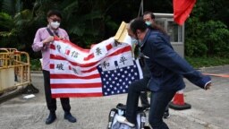 Seorang demontran pro-Beijing menginjak poster bergambar ketua DPR AS Nancy Pelosi dalam aksi protes di depan gedung Konsulat AS di Hong Kong, pada 3 Agustus 2022. Protes dilakukan setelah Pelosi memutuskan berkunjung ke Taiwan dalam lawatannya ke Asia. (Foto: AFP/Peter Parks)