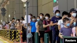 FILE – Residents line up to get tested for COVID-19 in Macau, China, on July 4, 2022. This week, after a person who traveled to a nearby city was found to have been infected with the virus, week, authorities told residents to conduct at least two days of COVID-19 tests.