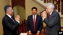 斯里蘭卡總統辦公室發表的這張照片顯示，拉尼爾·維克勒馬辛哈（Ranil Wickremesinghe）2022年7月15日宣誓就任斯里蘭卡代。圖為維克勒馬辛哈代總統7月15日在科倫坡宣誓就職後同大法官賈揚塔·賈亞蘇里亞(Jayantha Jayasuriyareets）以及大法官阿揚莎·賈亞蘇里亞(Jayantha Jayasuriya)會談。