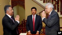 In this photograph provided by the Sri Lankan President's Office, interim President Ranil Wickremesinghe, right, greets Chief Justice Jayantha Jayasuriya during the oath-taking ceremony in Colombo, Sri Lanka, July 15, 2022.