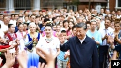 FILE - In this photo released by China's Xinhua News Agency, Chinese President Xi Jinping, center, visits Guyuanxiang in the Tianshan District in Urumqi, in northwestern China's Xinjiang Uyghur Autonomous Region, July 13, 2022.