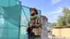 A Taliban fighter stands guard near the site where al-Qaida leader Ayman al-Zawahiri was killed in a U.S. strike over the weekend, in Kabul, Afghanistan, Aug. 2, 2022. 