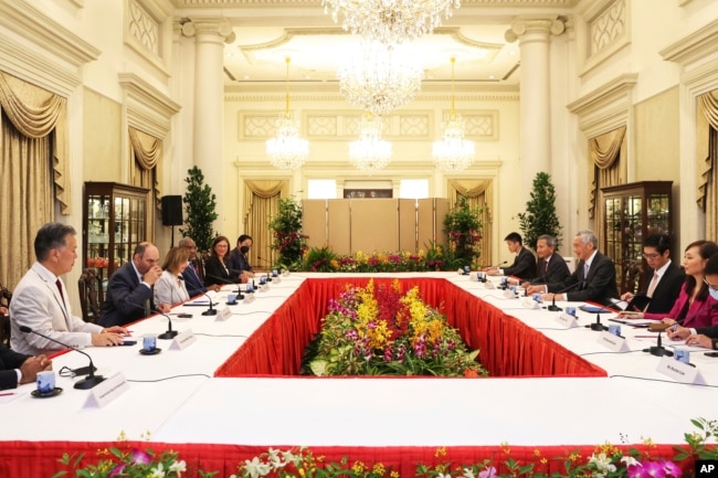 In this photo provided by Ministry of Communications and Information, Singapore, U.S. House Speaker Nancy Pelosi, fourth from left, and Prime Minister Lee Hsien Loong, fourth from right, meet at the Istana Presidential Palace in Singapore, Monday, Aug. 1,