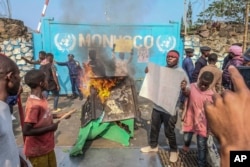 A resident holds a placard reading ''MONUSCO get out without delay'' during protests against the United Nations peacekeeping force MONUSCO)deployed in the Democratic Republic of Congo, in Goma, July 25, 2022.