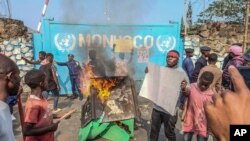 A resident holds a placard reading ''MONUSCO get out without delay'' during protests against the United Nations peacekeeping force (MONUSCO) deployed in the Democratic Republic of the Congo, in Goma, July 25, 2022.
