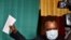 FILE - Incumbent President Denis Sassou Nguesso holds up his ballot before casting it at a polling station in Brazzaville, Republic of Congo, March 21, 2021. 