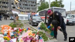 FILE - A Ukrainian serviceman lays flowers at the site of a Russian shelling on Thursday, in Vinnytsia, July 15, 2022. Russian missiles struck the central Ukrainian City the previous day, killing at least 23 people and injuring more than 100 others.