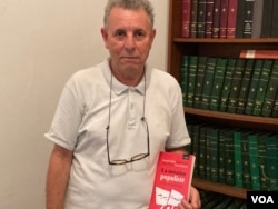 Tunis University professor Hamadi Redissi with a book he co-authored on Tunisia's 2019 elections. (Lisa Bryant/VOA)