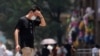 A man wearing face mask reacts on a street amid a heatwave warning, following the coronavirus disease (COVID-19) outbreak in Shanghai, China, July 13, 2022. 