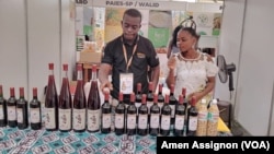 L'entrepreneur Kanyi Ben (à g.) lors d'une séance de dégustation de son vin à base de fruits à Lomé, Togo, juillet 2022. 