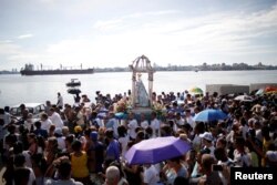 Cubanos asisten a la procesión en honor a la Virgen de Regla, en La Habana, Cuba.