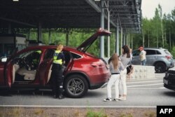 Petugas bea cukai memeriksa mobil dari Rusia di persimpangan perbatasan Nuijamaa, Finlandia, pada 28 Juli 2022.(Alessandro RAMPAZZO / AFP)