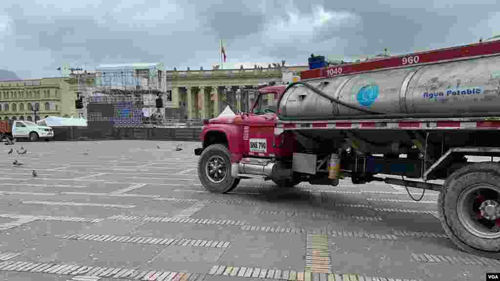 Un camión de agua potable entró en la Plaza de Bolívar donde se adelanta el trabajo para montar la tarima del evento protocolario de este domingo en Bogotá, Colombia.