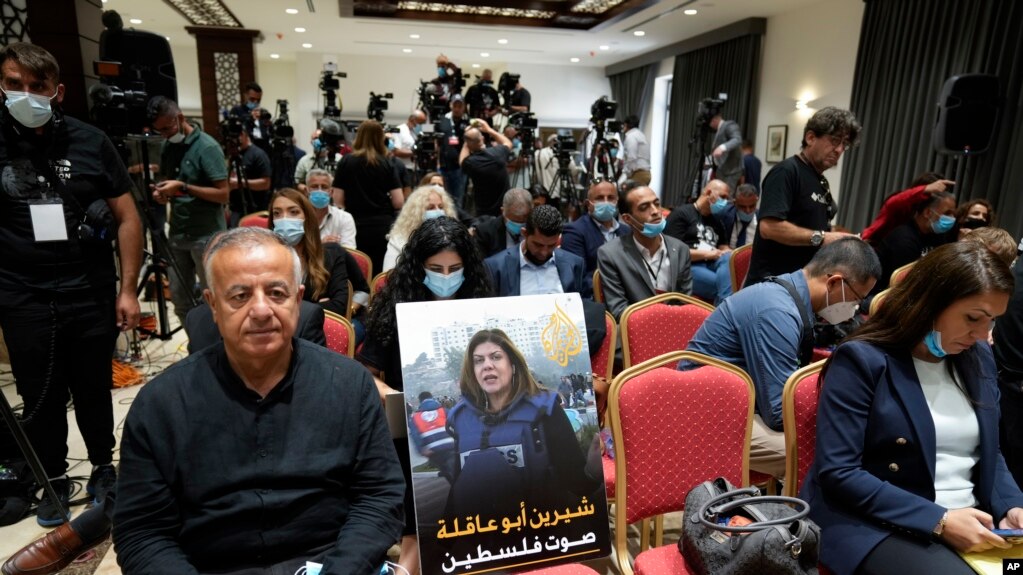 在记者们等待美国总统拜登与巴勒斯坦人领袖阿巴斯伯利恒会晤后对媒体发表谈话期间，人们把遇害记者阿克勒的招贴画放在一张空椅子上。(2022年7月15日)(photo:VOA)