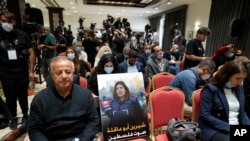 在記者們等待美國總統拜登與巴勒斯坦人領袖阿巴斯伯利恆會晤後對媒體發表談話期間，人們把遇害記者阿克勒的招貼畫放在一張空椅子上。 (2022年7月15日)