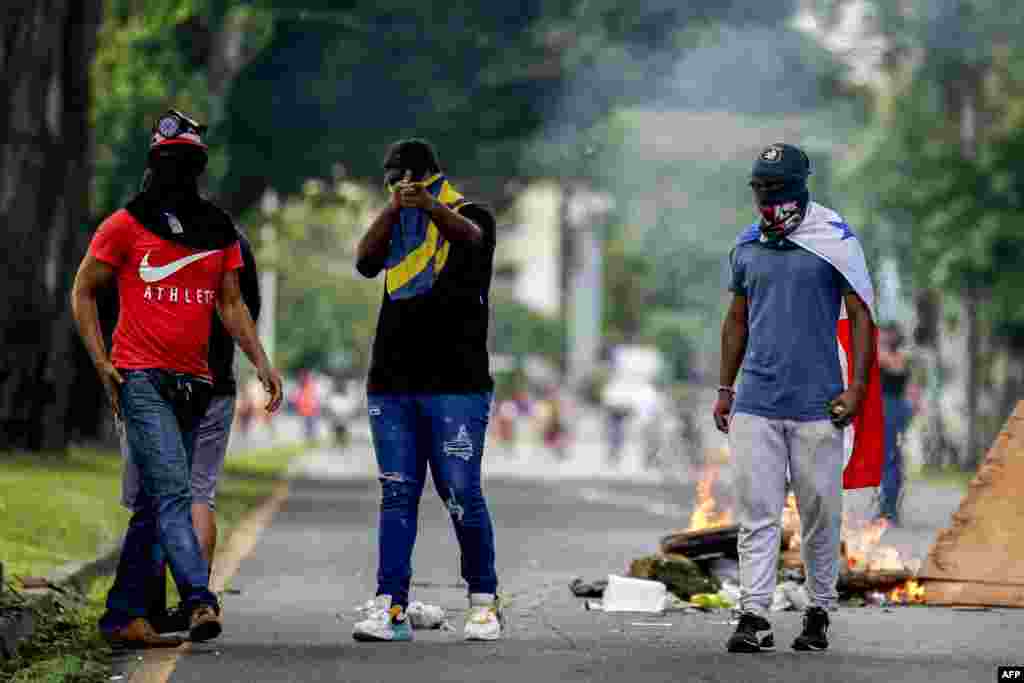 Con banderas panameñas colgadas en sus cuellos, manifestantes bloquean las calles y avenidas en Panamá, el 11 de julio de 2022.