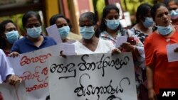 Health workers hold placards and shout slogans against Sri Lankan President Ranil Wickremesinghe during a protest in Colombo on July 23, 2022.