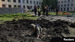 A sapper works at a compound of the National Academy of Urban Economy damaged by a Russian military strike, as Russia's attack on Ukraine continues, in Kharkiv, Ukraine July 23, 2022. 