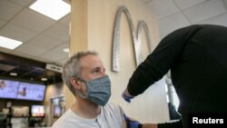 資料照片：一位男士在芝加哥的一家麥當勞餐廳接種新冠疫苗加強針。 (2021年12月21日)