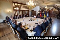Russian, top left, and Ukranian, right, delegations meet along with United Nation observers, left, and Turkish Defense Ministry members in Istanbul, Turkey, July 13, 2022.