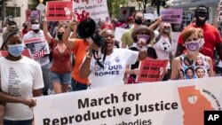 FILE - Protesters participate in the March for Reproductive Justice on Oct. 2, 2021, in downtown Atlanta.