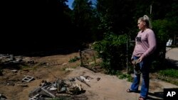 Angel Campbell stands on Aug. 4, 2022, near where the house of her grandmother, Nellie Mae Howard, had been in Chavies, Kentucky, until it was swept away in massive flooding. Howard died in the flood. 