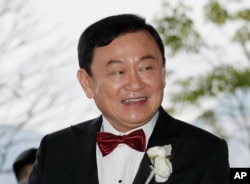 FILE - In this Friday, March 22, 2019 file photo, Former Thai Prime Minister Thaksin Shinawatra welcomes his guests for the wedding of his youngest daughter Paetongtarn "Ing" Shinawatra at a hotel in Hong Kong.