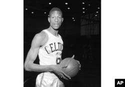 FILE - Bill Russell, of San Francisco, wears a Boston Celtics uniform for his first workout with the NBA team shortly after having signed a contract in Boston on Dec. 19, 1956.