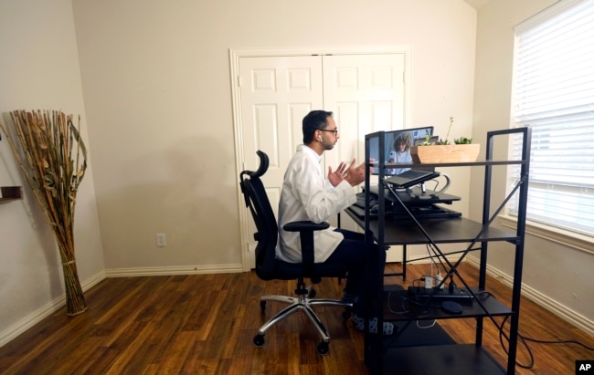 Dr. Vibin Roy speaks to a patient during an online appointment from his home in Keller, Texas, April 23, 2021. (AP Photo/LM Otero)