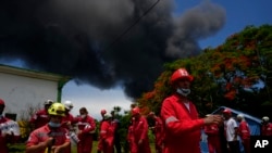 Miembros de la Cruz Roja Cubana se preparan para ser transportados a la Base de Supertanqueros de Matanzas, donde los bomberos trabajan para sofocar un incendio que comenzó durante una tormenta eléctrica la noche anterior, en Matazanas, Cuba, el sábado 6 de agosto de 2022. El incendio se descontroló el sábado. Cuatro explosiones y llamas hirieron a decenas de personas y dejaron a más de una docena de bomberos desaparecidos, dijeron las autoridades cubanas. (Foto AP/Ramón Espinosa)