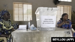 FILE: Polling station officials wait for voters in Dakar on July 31, 2022 during the legislative elections in Senegal.