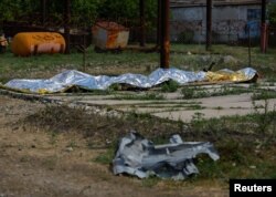 Burnt bodies of detainees lie covered following the shelling at a pre-trial detention center in the course of Ukraine-Russia conflict, in the settlement of Olenivka in the Donetsk Region, Ukraine July 29, 2022.