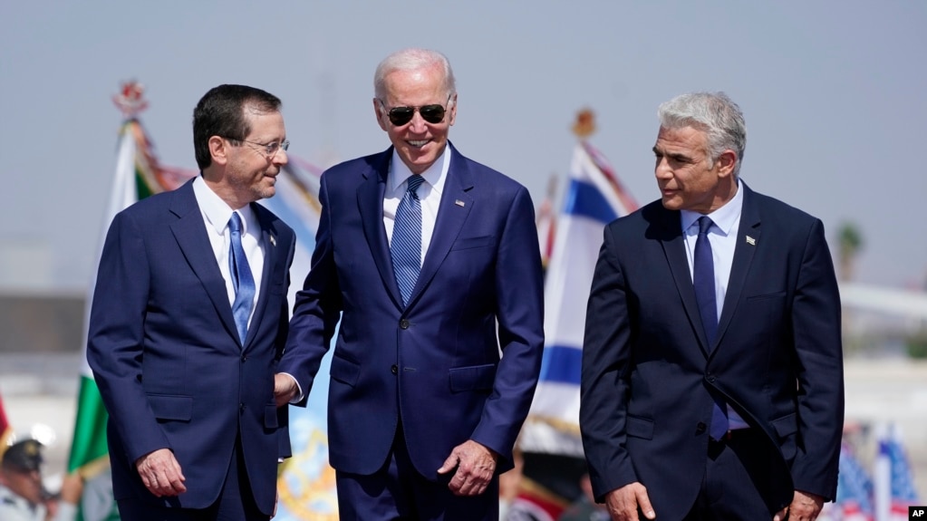 美国总统拜登在以色列本·古里安机场与以色列总统赫尔佐格(左)和总理拉皮德(右)站在一起。(2022年7月13日)(photo:VOA)