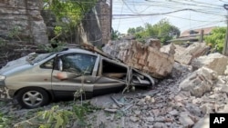Un vehículo resulta dañado luego de que un muro se derrumbó por un fuerte terremoto que sacudió Vigan, provincia de Ilocos Sur, Filipinas, el miércoles 27 de julio de 2022. (Oficina de Protección contra Incendios vía AP)