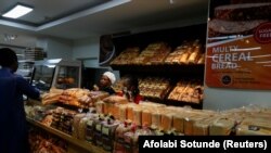 FILE: People stand near the bread stand as they shop at Cherries Hypermarket in Abuja, Nigeria March 15, 2022.