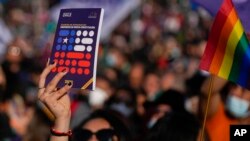 Una mujer sostiene un folleto de la nueva Constitución propuesta por una Convención Constituyente mientras participa en una manifestación a favor con miras al plebiscito del 4 de septiembre, en el barrio de Maipú de Santiago, Chile, el sábado 23 de julio de 2022. 