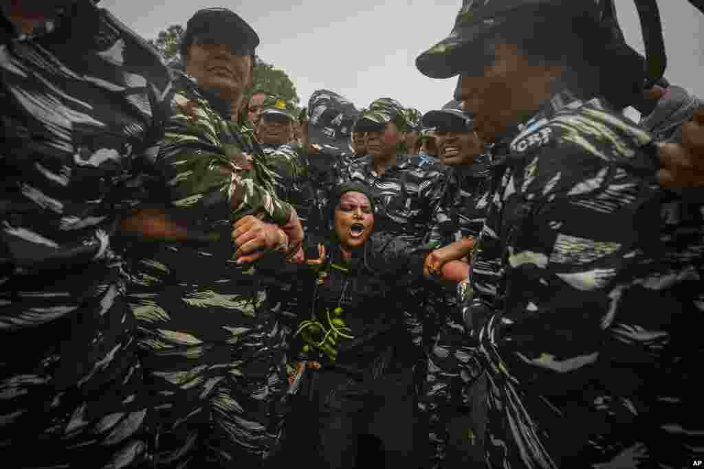 Indian paramilitary soldiers detain a lawmaker from India's opposition Congress party during a protest in New Delhi, India.