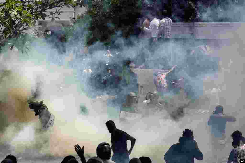 Army soldiers are caught in tear smoke with protesters storming the compound of Prime Minister Ranil Wickremesinghe&#39;s office in Colombo, July 13, 2022