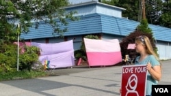 Natalie, 24, protests next to a women’s center that offers abortions. Abortion rights activists protect the identity and arrival of patients with bed sheet tunnels to the office door. (Carolyn Presutti/VOA)