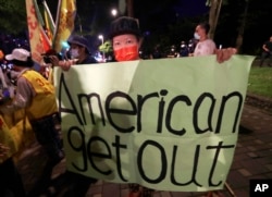 A protester holds a banner during a protest against the visit of United States House Speaker Nancy Pelosi, outside a hotel in Taipei, Taiwan, Aug. 2, 2022.