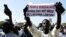 FILE — A man holds a sign reading 'No to LGBT agenda' during a protest called by religious associations against homosexuality on May 23, 2021, on the Obelisque square in Dakar.