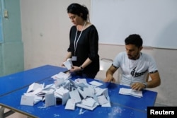 Members of the election committee count votes at a polling station during a referendum on a new constitution in Tunis, Tunisia, July 25, 2022.