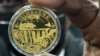 A Reserve Bank of Zimbabwe official displays the newly introduced gold coin in Harare, July 25, 2022. 