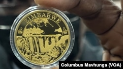 A Reserve Bank of Zimbabwe official displays the newly introduced gold coin in Harare, July 25, 2022. 