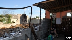 Yaana, 33, eats at her house, which was destroyed as a result of shelling in village of Moshchun, Kyiv region, on July 28, 2022, amid the Russian military invasion of Ukraine.