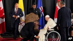 Ayudan al Papa Francisco a sentarse en su silla de ruedas después de una ceremonia de bienvenida el domingo 24 de julio de 2022 en Edmonton, Alberta, Canadá. (Foto AP/Eric Gay)