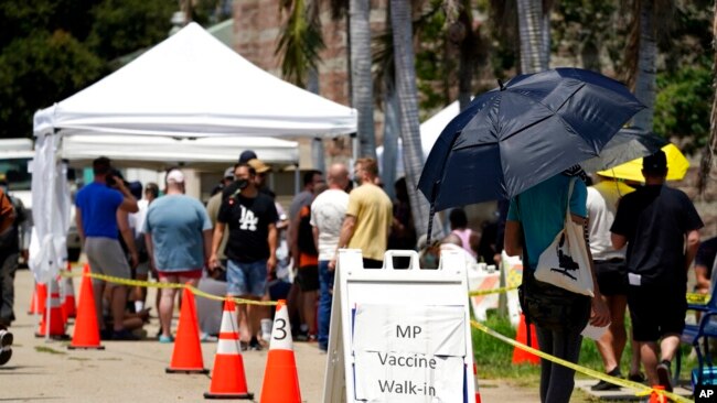 FILE - People line up at a monkeypox vaccination site, July 28, 2022, in Encino, Calif. California's public health officer said the state is pressing for more vaccine and closely monitoring the spread of the monkeypox virus.
