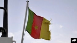 FILE - A Cameroonian flag flies on a ship at the port in Douala, Cameroon, Apr. 10, 2022.