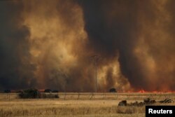Api kebakaran mencapai ladang gandum dekat Tabara, Zamora, di Spanyol, yang didera gelombang panas kedua tahun ini, 18 Juli 2022. (REUTERS/Isabel Infantes)